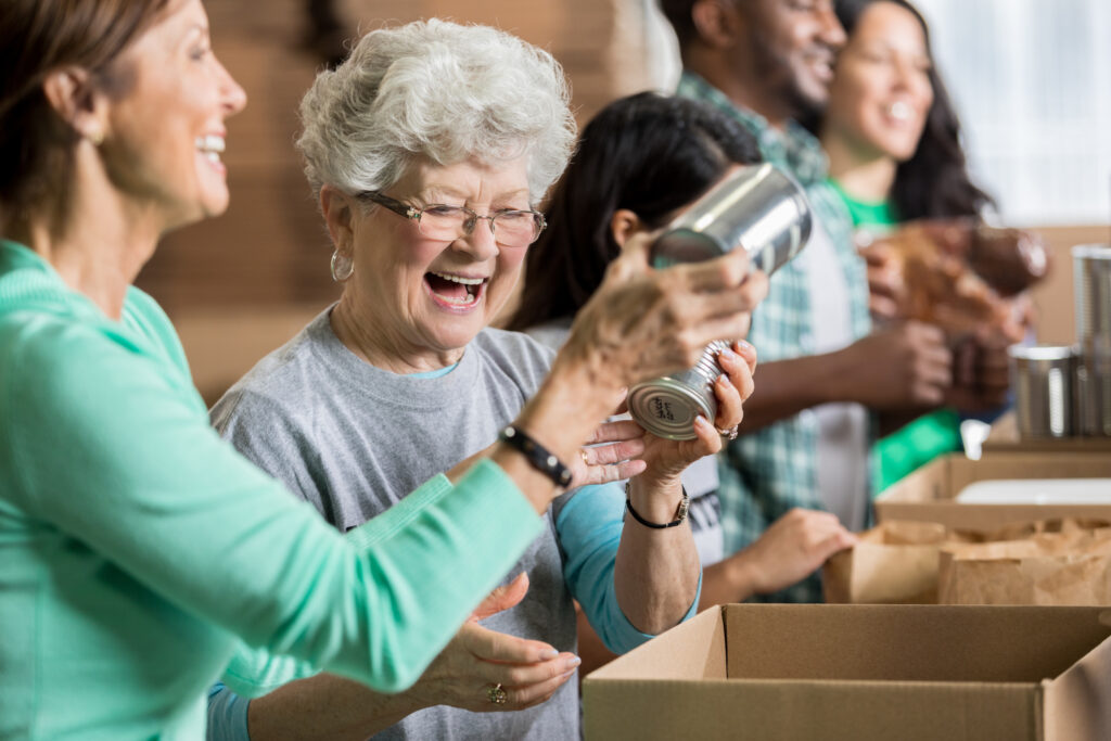 Happy female friends volunteer at charity food bank