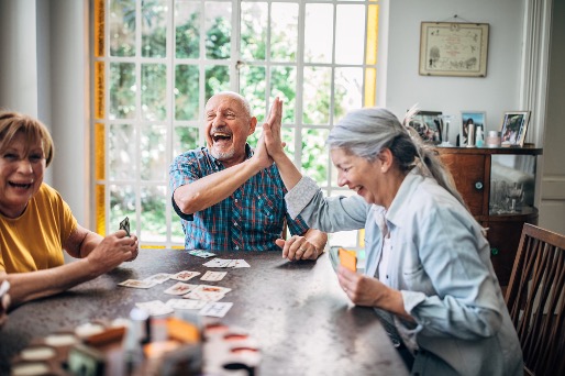 three people playing cards together at a table