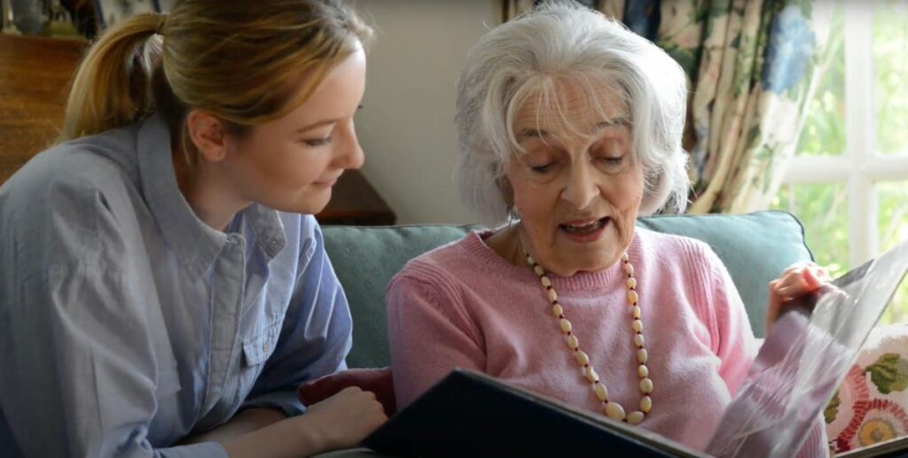 a young woman and an elderly woman reading together