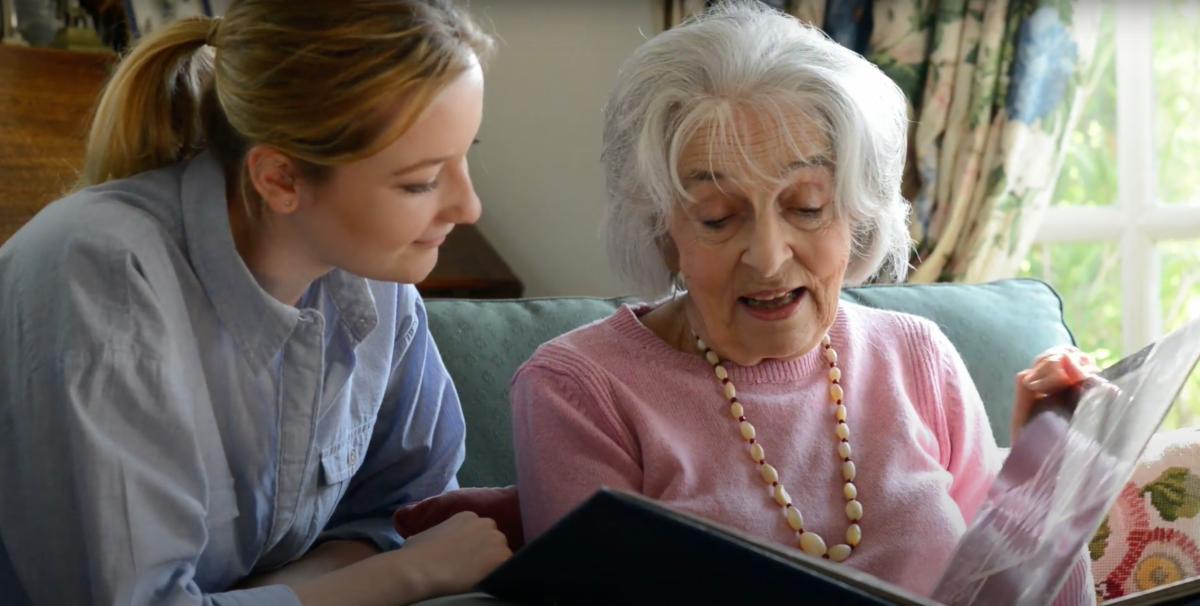 a young woman and an elderly woman reading together