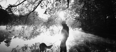 a person walking their dog by a lake